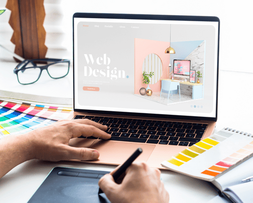A web designer creating a website on a laptop.