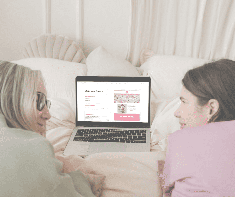 two women performing laptop maintenance on a bed.