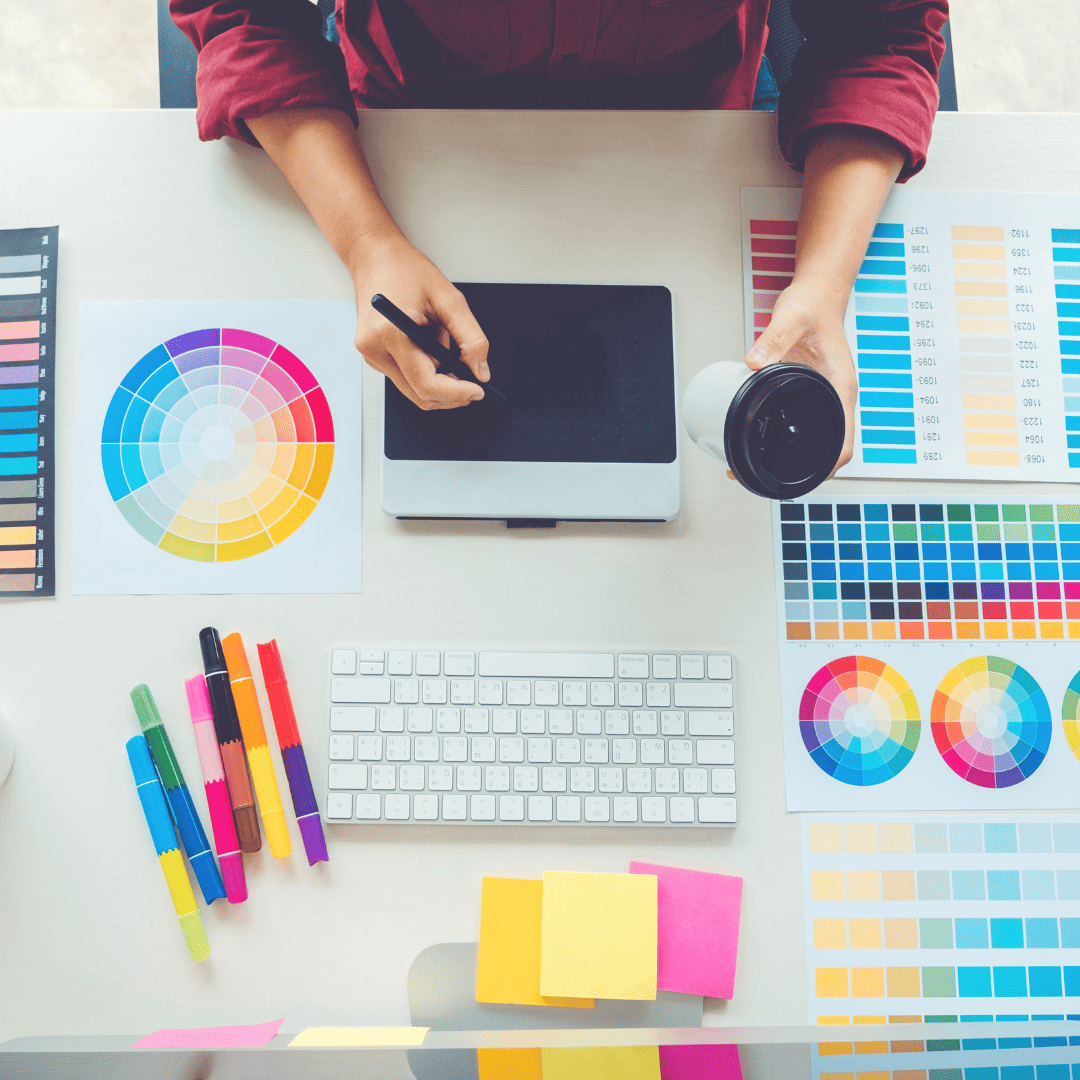 a woman is sitting at a desk with color swatches, focusing on professional branding.